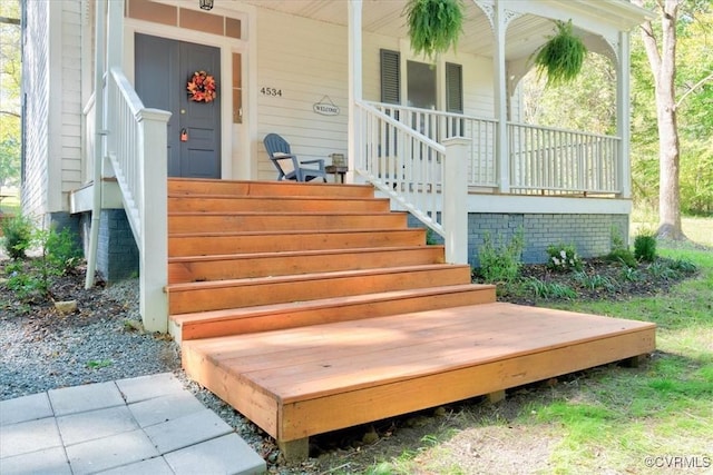 view of exterior entry featuring covered porch