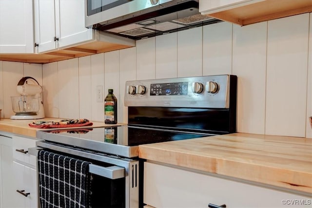 kitchen featuring butcher block counters, decorative backsplash, white cabinets, and stainless steel appliances