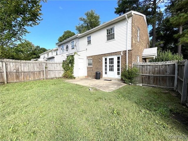 rear view of house featuring a patio area, a lawn, and french doors