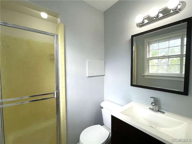 bathroom with toilet, walk in shower, and vanity