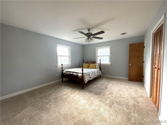 unfurnished bedroom featuring ceiling fan, a closet, and light colored carpet