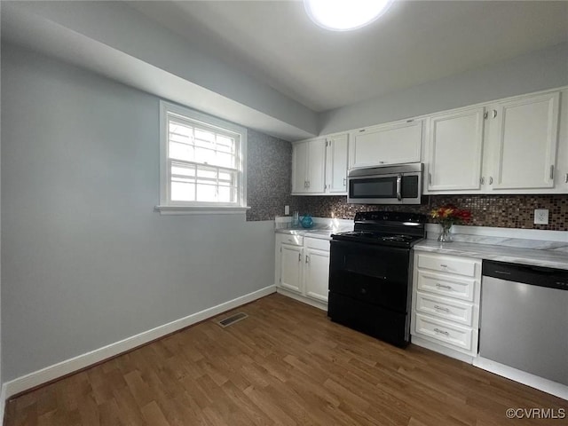 kitchen featuring appliances with stainless steel finishes, dark hardwood / wood-style flooring, white cabinets, and tasteful backsplash