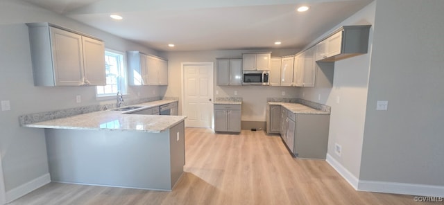 kitchen featuring gray cabinets, appliances with stainless steel finishes, light hardwood / wood-style floors, and sink