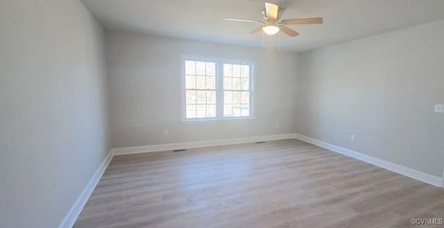 empty room with ceiling fan and light hardwood / wood-style floors