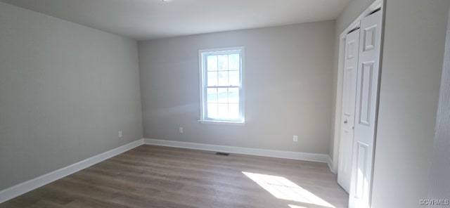 unfurnished bedroom featuring a closet and hardwood / wood-style floors