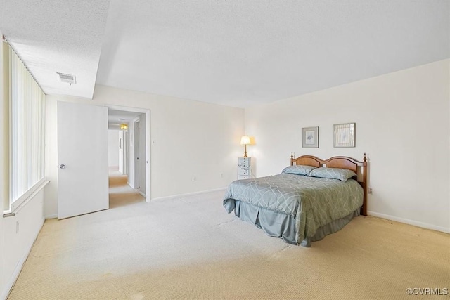 bedroom with light carpet and a textured ceiling