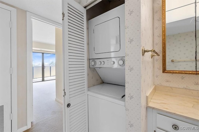 washroom with stacked washer / drying machine and light colored carpet