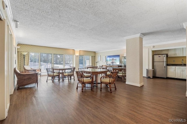 dining room featuring crown molding, dark wood-type flooring, and a textured ceiling