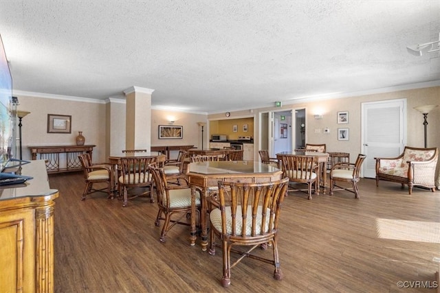 dining space with ornamental molding, a textured ceiling, and dark hardwood / wood-style flooring