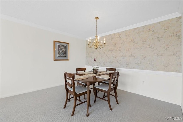 dining space with ornamental molding, a chandelier, and carpet