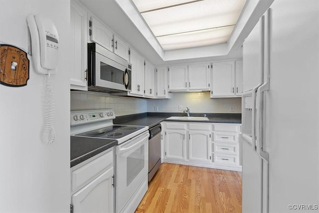 kitchen with sink, light hardwood / wood-style floors, white cabinets, and appliances with stainless steel finishes