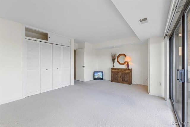 unfurnished bedroom featuring a closet and light carpet