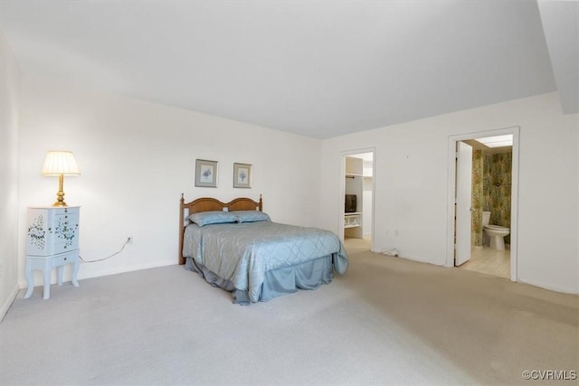 bedroom with light colored carpet and ensuite bath