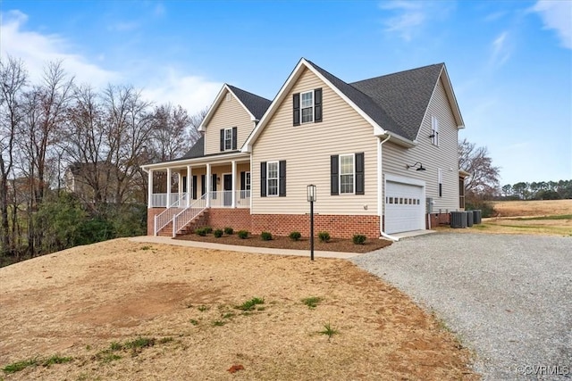 view of front property featuring covered porch, a garage, and central air condition unit