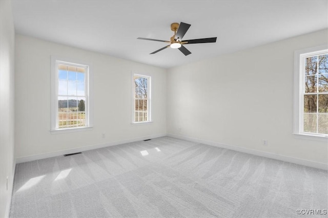 empty room featuring ceiling fan and light colored carpet