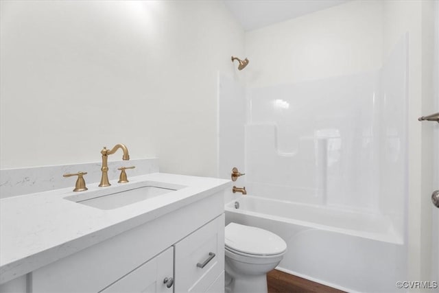 full bathroom featuring hardwood / wood-style flooring, shower / bathing tub combination, toilet, and vanity