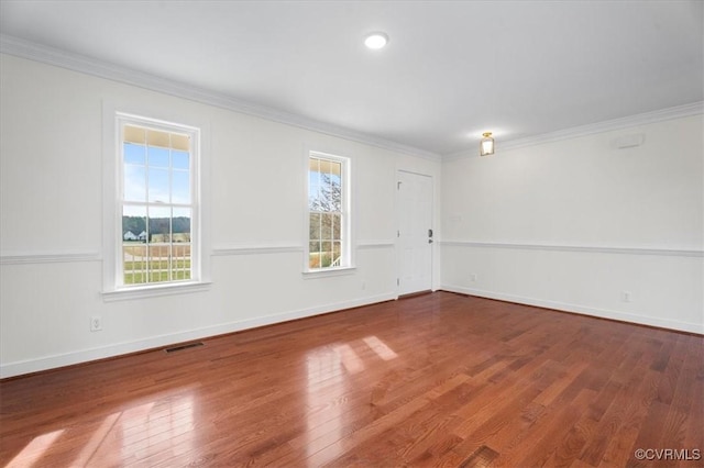 empty room featuring ornamental molding and hardwood / wood-style flooring