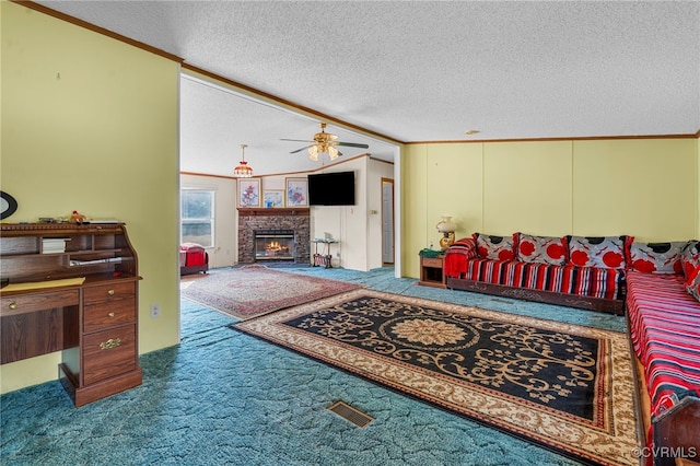 living room featuring ceiling fan, carpet, crown molding, a stone fireplace, and a textured ceiling