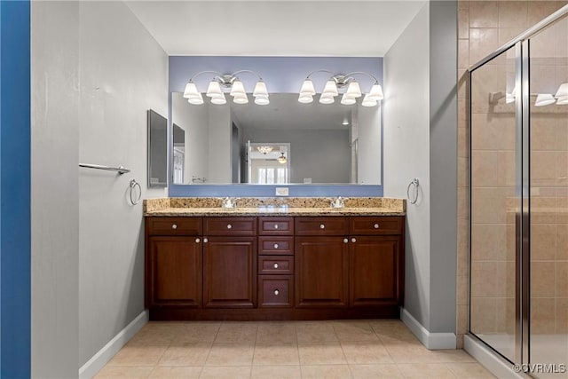 bathroom with a shower with shower door, vanity, and tile patterned flooring