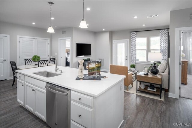 kitchen with a center island with sink, stainless steel dishwasher, sink, hanging light fixtures, and white cabinets