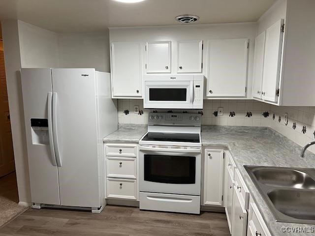 kitchen featuring white cabinetry, sink, backsplash, and white appliances