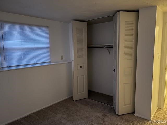 unfurnished bedroom with carpet floors and a closet