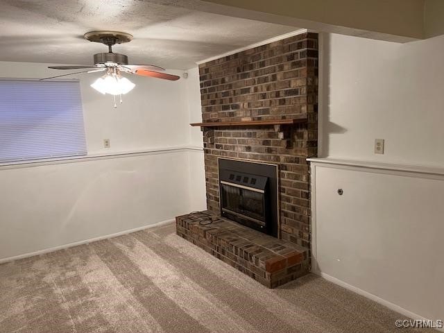 unfurnished living room featuring carpet floors, a textured ceiling, a brick fireplace, and ceiling fan