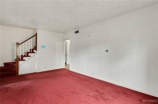 carpeted spare room with a textured ceiling