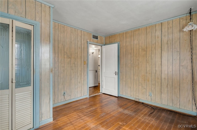 spare room with wooden walls and dark hardwood / wood-style flooring