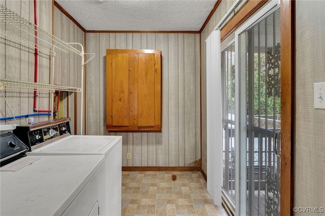 laundry area featuring crown molding, separate washer and dryer, a textured ceiling, and wood walls