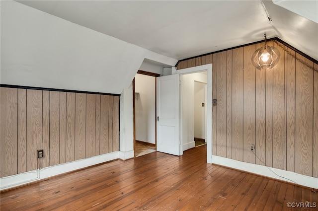 bonus room with lofted ceiling, hardwood / wood-style floors, and wood walls