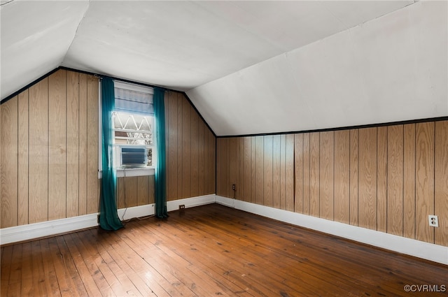 bonus room featuring lofted ceiling, hardwood / wood-style floors, cooling unit, and wood walls