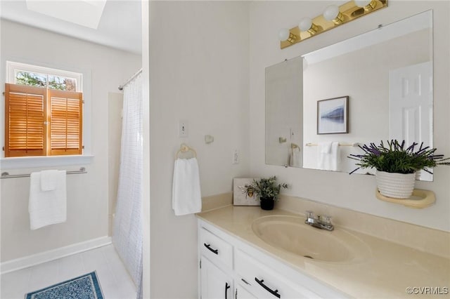 bathroom featuring vanity, tile patterned flooring, and a skylight