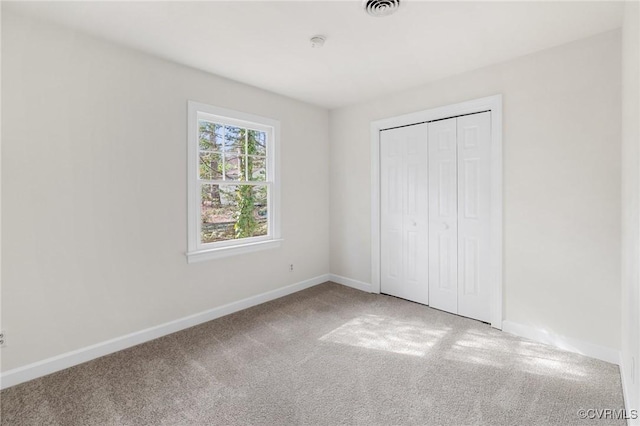 unfurnished bedroom featuring carpet floors and a closet