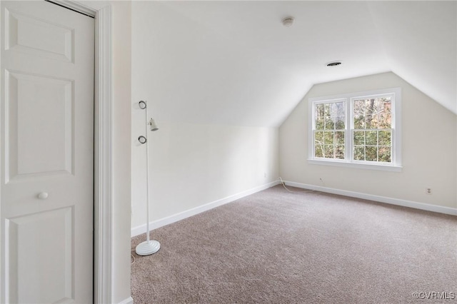 additional living space featuring carpet floors and vaulted ceiling