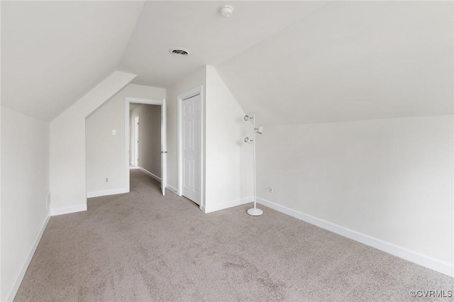 additional living space with vaulted ceiling and light carpet