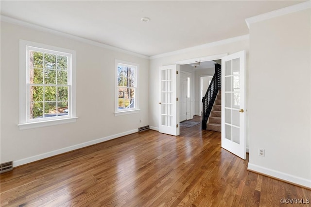 spare room featuring french doors, ornamental molding, and dark hardwood / wood-style floors