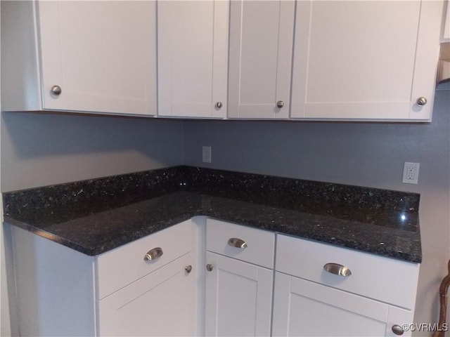 kitchen with white cabinets and dark stone counters