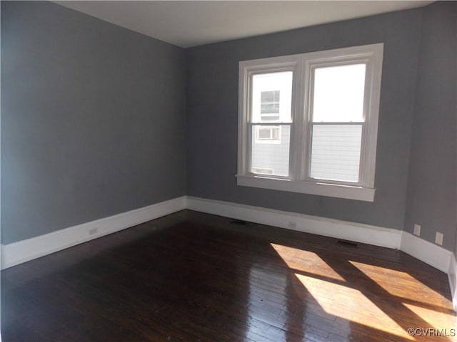 unfurnished room with dark wood-type flooring