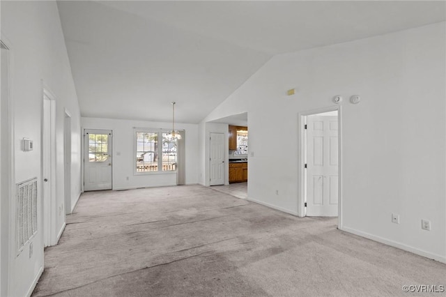 unfurnished living room featuring light colored carpet, a chandelier, and vaulted ceiling