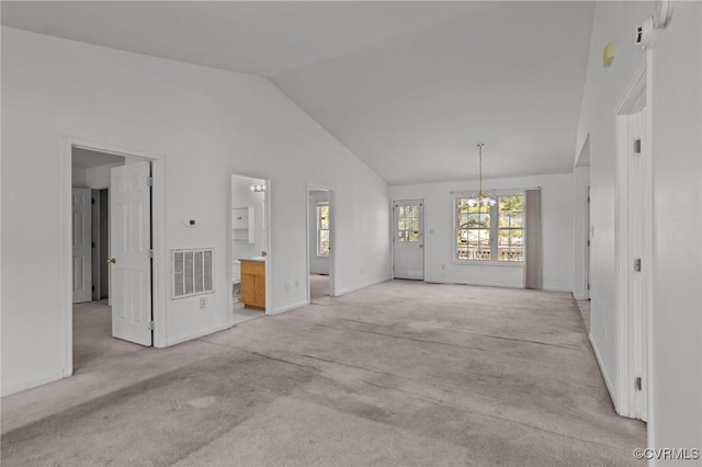 interior space with high vaulted ceiling, light colored carpet, and a chandelier