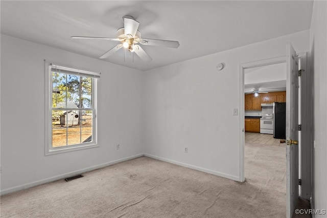 unfurnished room with light colored carpet and ceiling fan