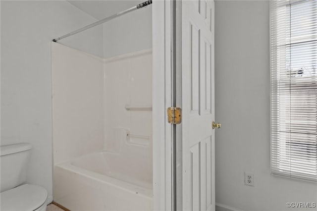 bathroom featuring shower / tub combination and toilet