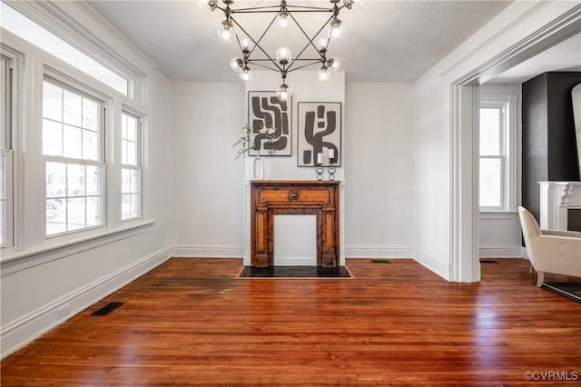 unfurnished dining area featuring wood-type flooring and a notable chandelier