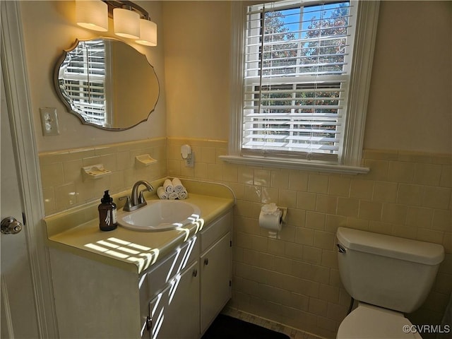 bathroom featuring tile walls, toilet, and vanity