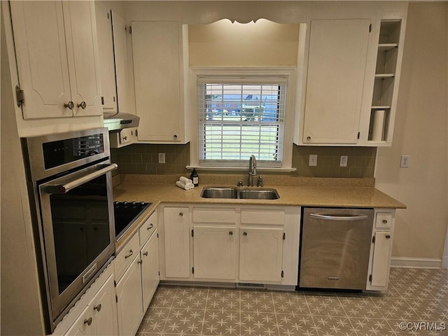 kitchen featuring stainless steel appliances, white cabinetry, tasteful backsplash, and sink