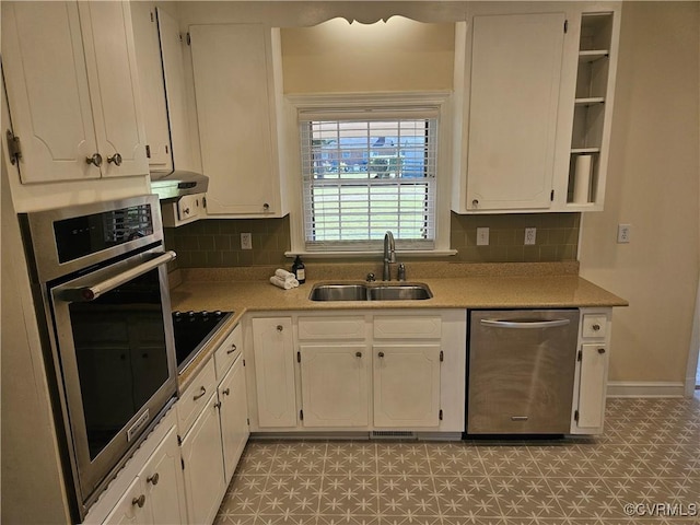 kitchen featuring decorative backsplash, appliances with stainless steel finishes, sink, and white cabinetry