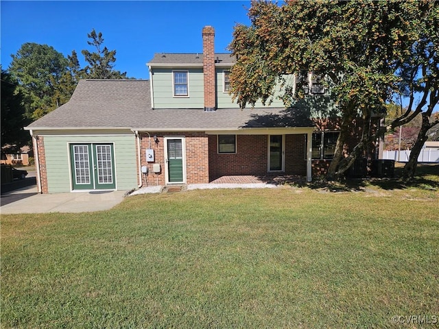 back of house with a lawn and a patio