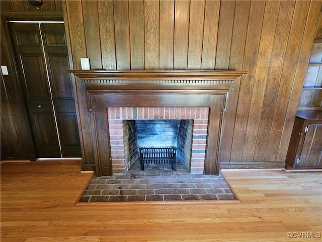 details with hardwood / wood-style flooring, wooden walls, and a fireplace