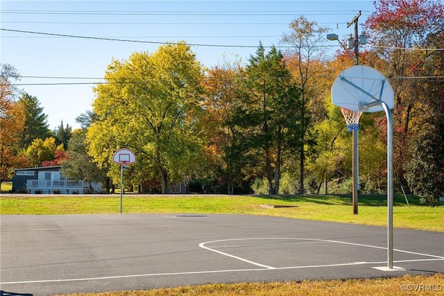 view of sport court with a yard